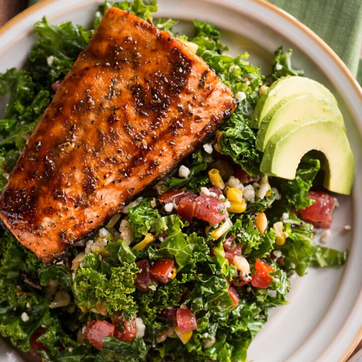 glazed salmon on a bed of greens with avocado - eat health fats to improve symptoms of estrogen dominance